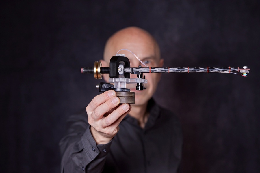 Side view of the flex tonearm (left). Matthias Kurz is holding the arm with his right hand outstretched